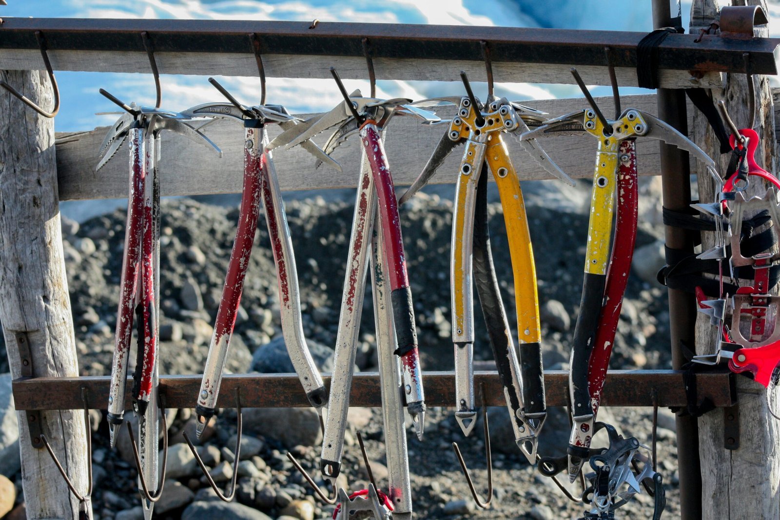 a bunch of skis hanging from a wooden fence